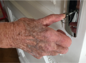 image showing a hand affected by rhizarthrosis who has difficulty opening a door